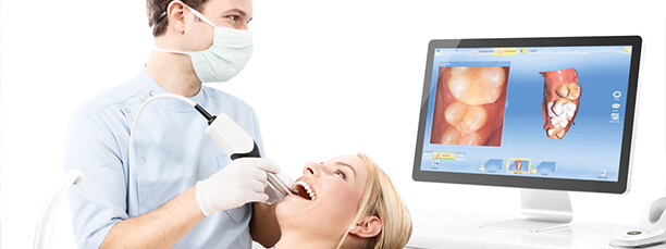 Dentist using CEREC system to view patient's smile