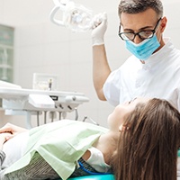 A dentist looking at a female patient’s mouth