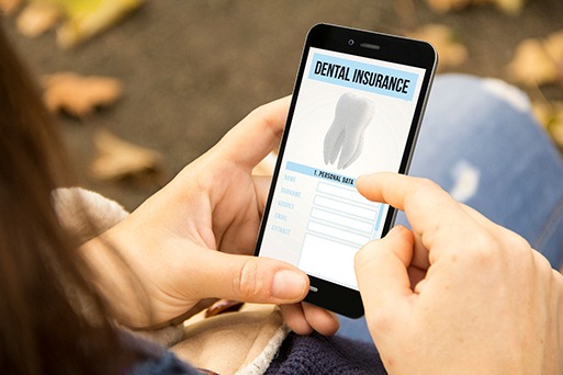 POV shot of woman looking at dental insurance form on phone