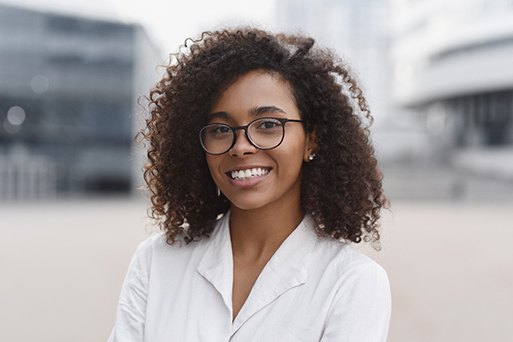 Woman with glasses smiling in city