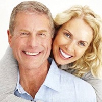 A happy middle-aged couple smiling and pleased with their new dental implants