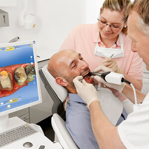 Male patient receiving CEREC dental scans