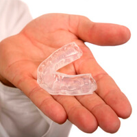 Hand holding a nightguard for bruxism treatment