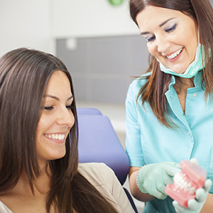 Woman and dentist looking at dental model