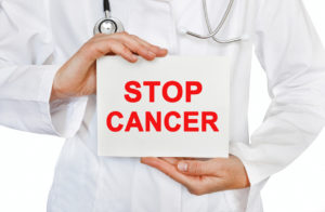 Doctor holding a sign reading stop cancer