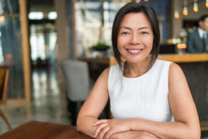 smiling woman sitting at a table 