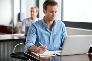 man looking at insurance policy on laptop