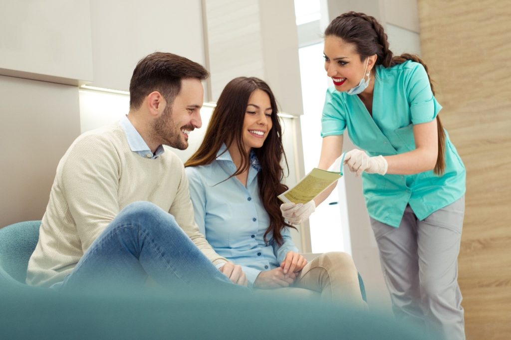 Dentist reviewing dental insurance paperwork with couple