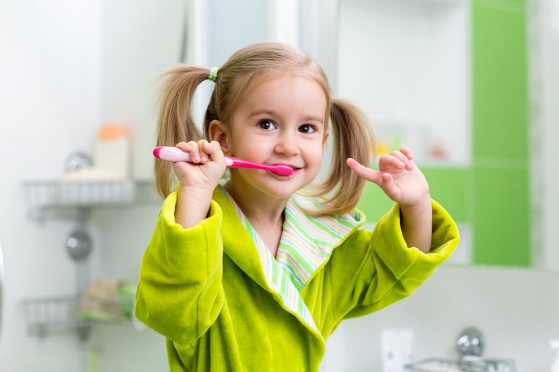 Little girl brushing her teeth in bathroom