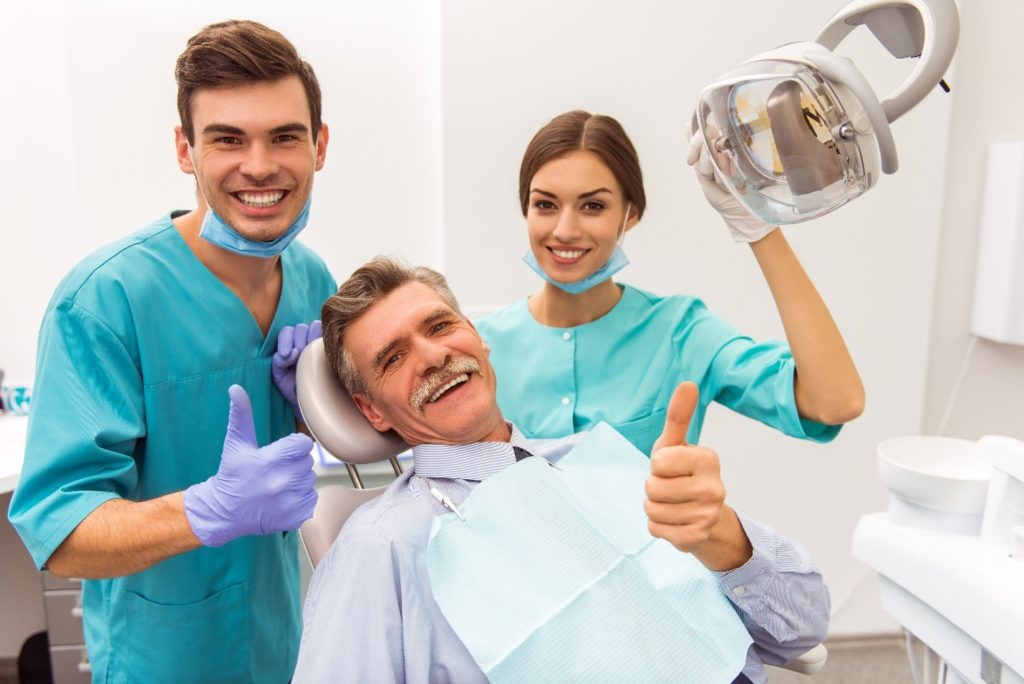 Dental assistants smiling with patient in dental office