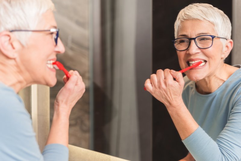 older woman brushing her teeth