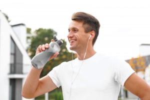 man drinking water after exercising