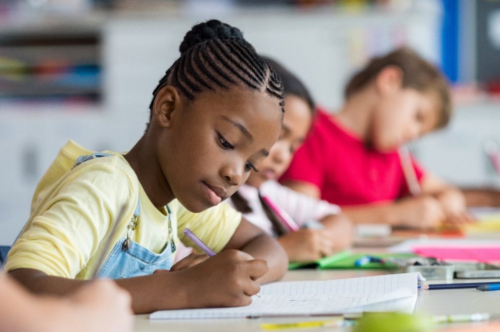 Young girl working on assignment in classroom